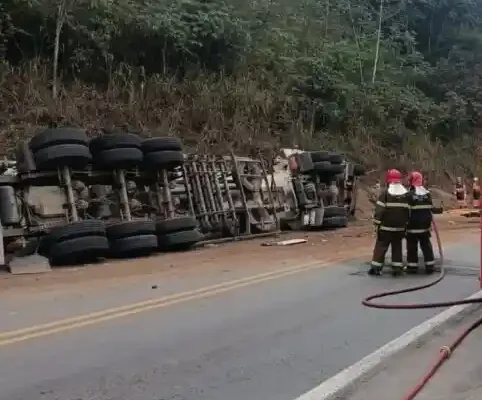 Carreta tombada às margens da BR-381, em Belo Oriente, enquanto bombeiros trabalham no local da ocorrência.