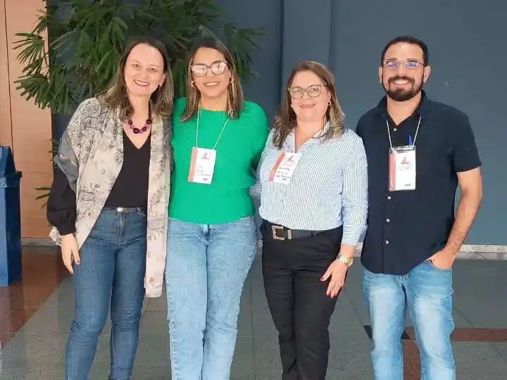 Quatro profissionais da saúde posam para foto durante evento realizado pela Secretaria de Estado da Saúde em Belo Horizonte. O encontro reuniu referências técnicas de IST/AIDS e hepatites virais, incluindo representantes de João Monlevade, para discutir estratégias de acolhimento e assistência aos usuários da rede pública de saúde.