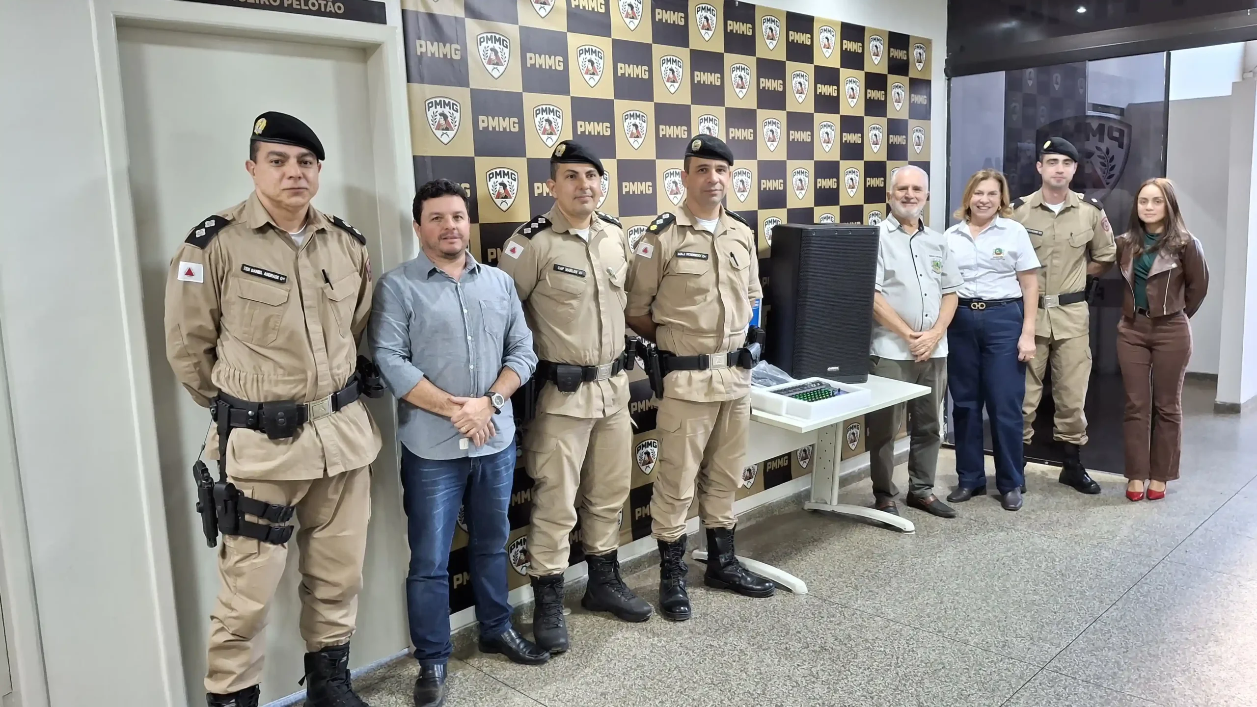 Grupo formado por autoridades municipais e policiais militares posa ao lado de equipamentos de sonorização adquiridos para o Proerd. Os materiais serão utilizados em formaturas e ações educativas promovidas pela Polícia Militar em João Monlevade.