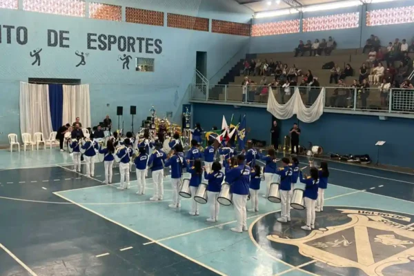 Alunos da Fanfarra da Emip realizam apresentação em ginásio esportivo diante de jurados e público durante o Campeonato Mineiro de Bandas e Fanfarras. O grupo representa João Monlevade e participou da competição realizada em Botelhos, no Sul de Minas.