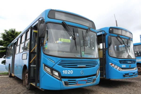 Dois ônibus azuis do transporte coletivo da Enscon estacionados lado a lado. A imagem ilustra a decisão da Prefeitura de João Monlevade de manter a tarifa do transporte coletivo congelada pelo sexto ano consecutivo.