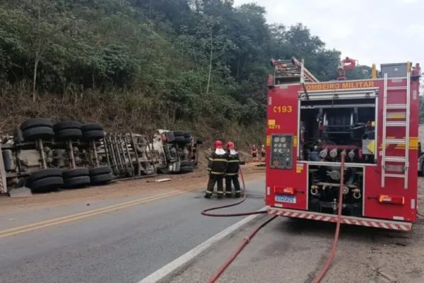 Viatura do Corpo de Bombeiros Militar posicionada na BR-381, em Belo Oriente, durante atendimento a um acidente envolvendo uma carreta tombada às margens da rodovia. Bombeiros atuam no local enquanto equipes trabalham para garantir a segurança da via.