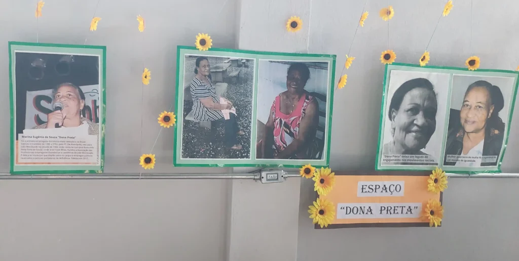 Painel de homenagem instalado na sede da Associação de Lavadeiras de Monlevade reúne fotografias e registros da trajetória de Marina Eugênia de Souza, a Dona Preta. A exposição destaca a fundadora da entidade e dá nome ao Espaço Dona Preta, criado para preservar sua memória e seu legado de luta em defesa das trabalhadoras domésticas e lavadeiras de João Monlevade.