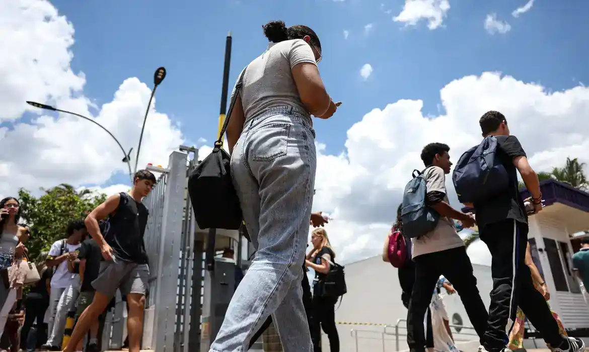 Grupo de estudantes circula em um campus educacional durante o dia. A imagem representa o período de inscrição do Enem 2026, que teve o prazo ampliado para permitir que mais candidatos garantam participação no exame nacional.