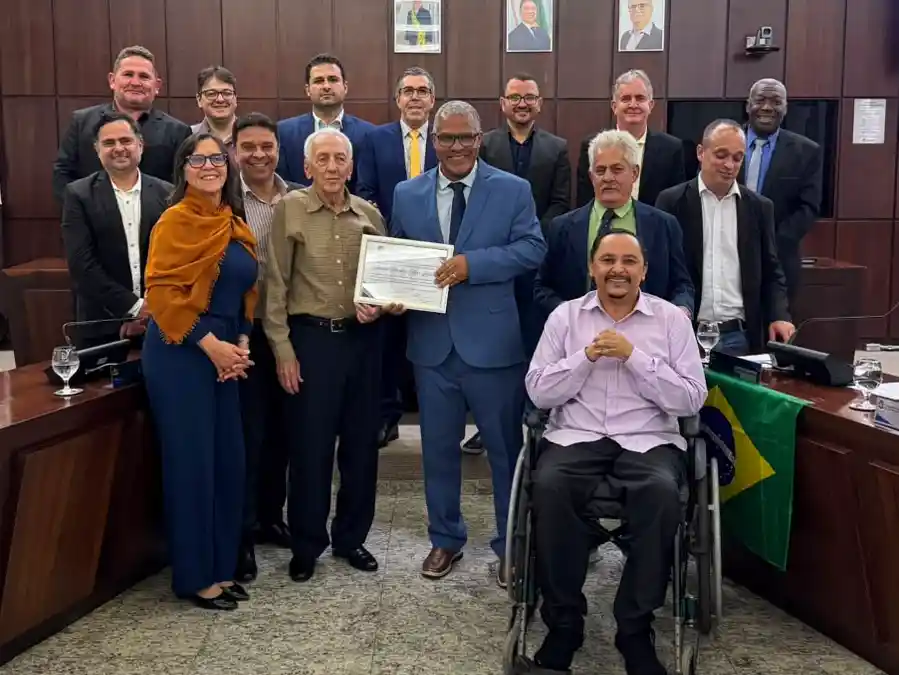 Autoridades, familiares e convidados posam para foto durante solenidade na Câmara Municipal de João Monlevade. Ao centro, o homenageado Antônio Sebastião Alves Linhares, conhecido como Nozinho, recebe certificado de Moção de Aplausos. A cerimônia reconheceu sua trajetória profissional e sua atuação comunitária, incluindo a participação na fundação da Colônia Bom Samaritano.