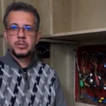 Padre Jefferson Veronês, pároco da Igreja São José Operário, com suéter quadriculado em tons branco, preto e cinza.