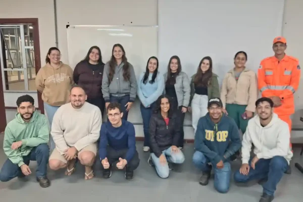 Grupo de estudantes da Engenharia de Produção da UFOP posa para foto ao lado de integrante do Corpo de Bombeiros após treinamento sobre segurança contra incêndio, prevenção de acidentes e procedimentos de emergência no campus João Monlevade.