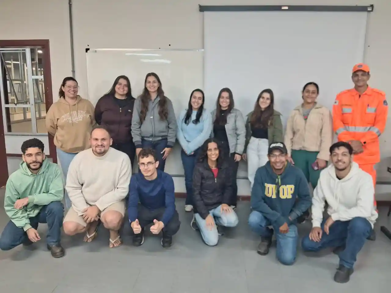 Grupo de estudantes da Engenharia de Produção da UFOP posa para foto ao lado de integrante do Corpo de Bombeiros após treinamento sobre segurança contra incêndio, prevenção de acidentes e procedimentos de emergência no campus João Monlevade.