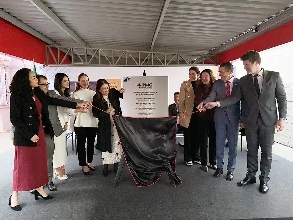Representantes do Ministério Público de Minas Gerais (MPMG) participam do descerramento da placa de inauguração da nova sede das Promotorias de Justiça de João Monlevade. A cerimônia ocorre em frente à placa comemorativa, marcando a entrega da nova estrutura destinada ao atendimento da população e às atividades do Ministério Público.