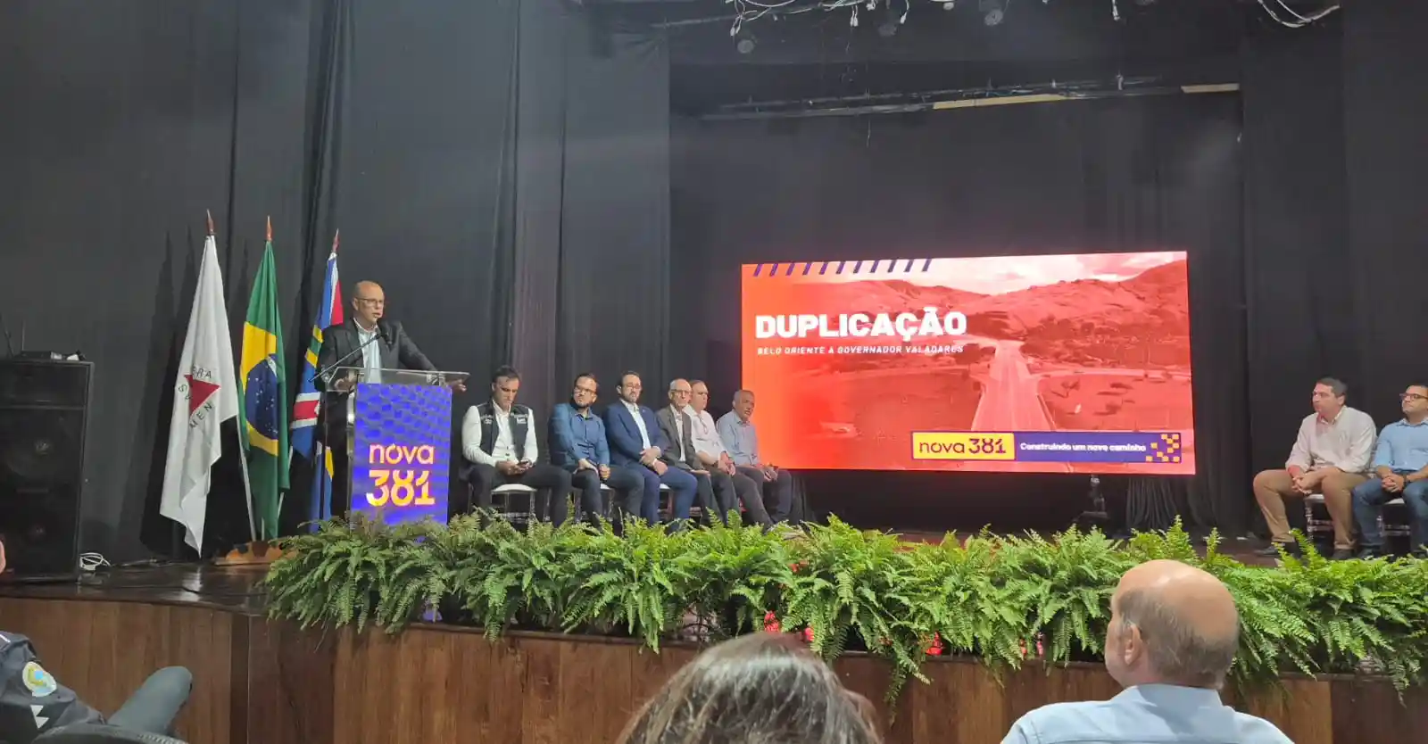 Auditório durante apresentação do estudo para a duplicação da BR-381. Ao fundo, um telão exibe a palavra "Duplicação" e informações sobre o trecho entre Belo Oriente e Governador Valadares, durante evento da Nova 381.