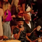 Imagem mostra os músicos do grupo Só Pra Contrariar se apresentando em um ambiente descontraído, cercados por instrumentos de samba, mesas e público ao fundo. A banda é uma das atrações confirmadas do Festival Gastronômico de Rio Piracicaba, que acontece em setembro de 2026 com entrada gratuita.