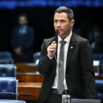Cleitinho discursa na tribuna do Senado Federal, segurando um microfone durante sessão no plenário.